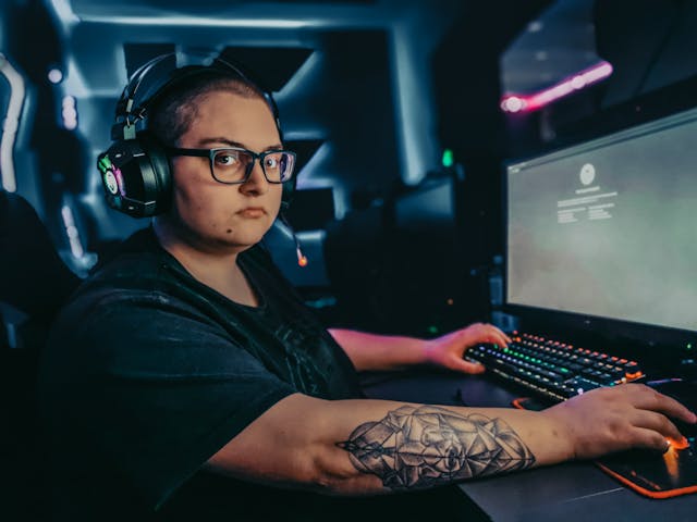 Focused e-sports player with headset in tournament setting