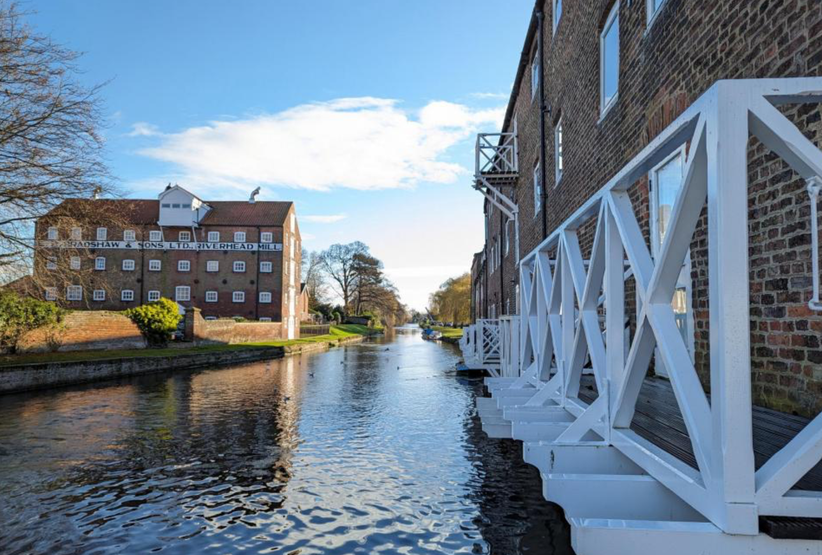Driffield canal scene with brick buildings and a white wooden bridge.